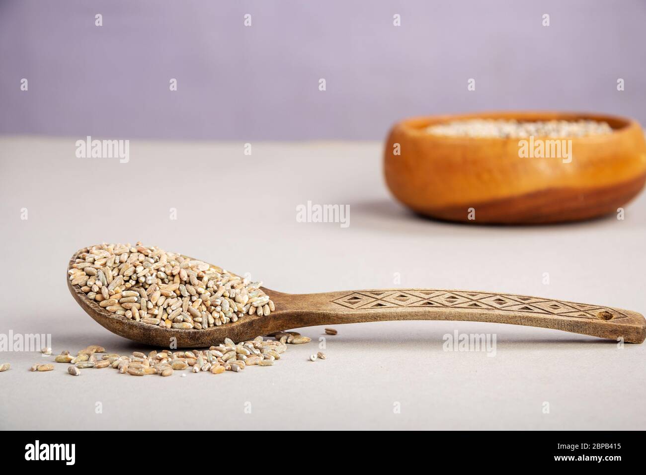 Ungeschälte RohHafer in einem Holzlöffel auf einem Holztisch Stockfoto