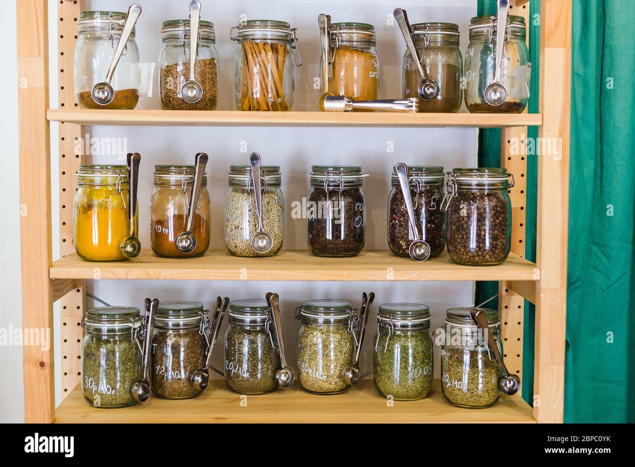 Regale mit einer Auswahl an Gewürzen und Körnern in Gläsern in Zero Waste Shop Stockfoto