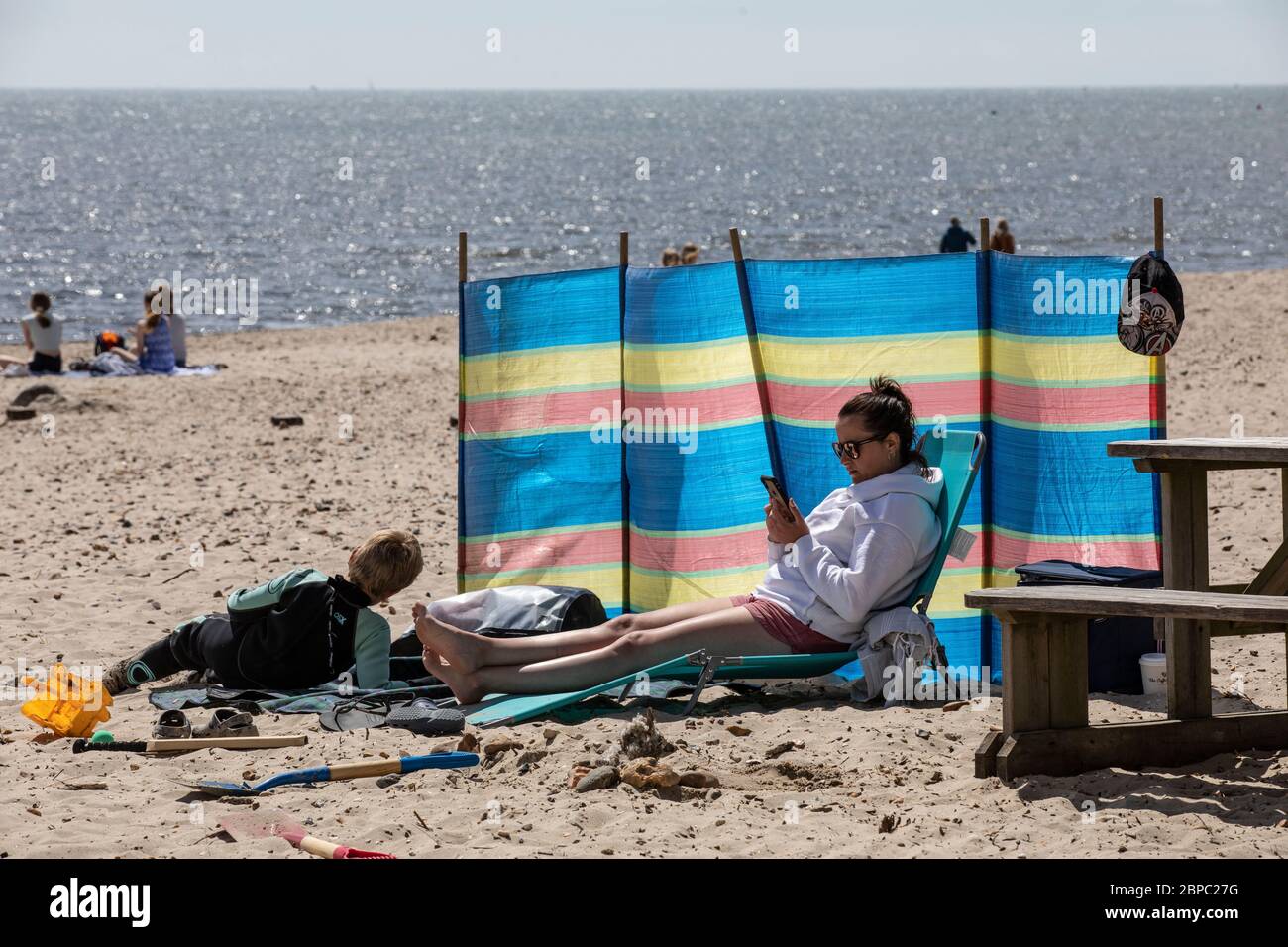 Die Menschen verbringen ihr erstes Wochenende seit der Coronavirus Lockdown Maßnahmen waren entspannt genießen, draußen am Strand in Mudeford, Dorset, England Stockfoto