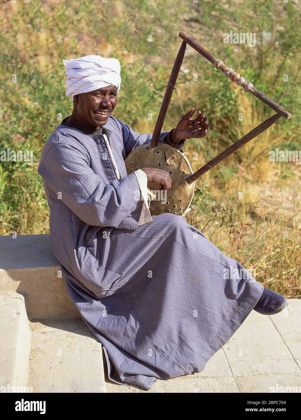 Lokaler Mann spielt Musiksaiteninstrument, Luxor, Luxor Governorate, Republik Ägypten Stockfoto