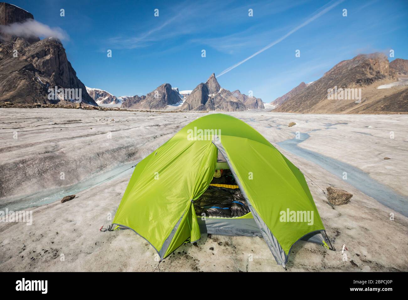 Bergsteigerzelt am Gletscher unterhalb dramatischer Berggipfel. Stockfoto