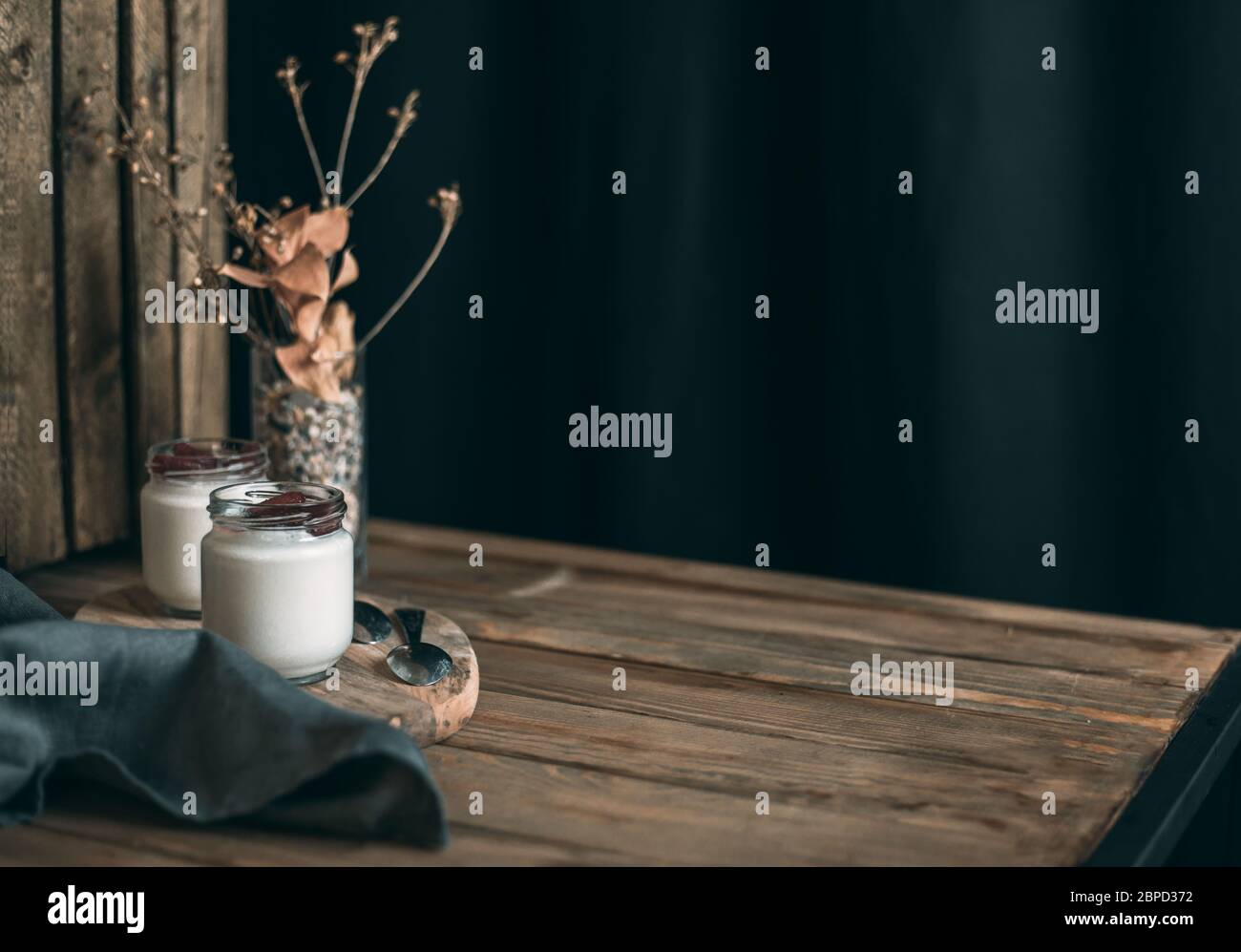 Zwei Gläser Joghurt auf einem Holzständer Stockfoto