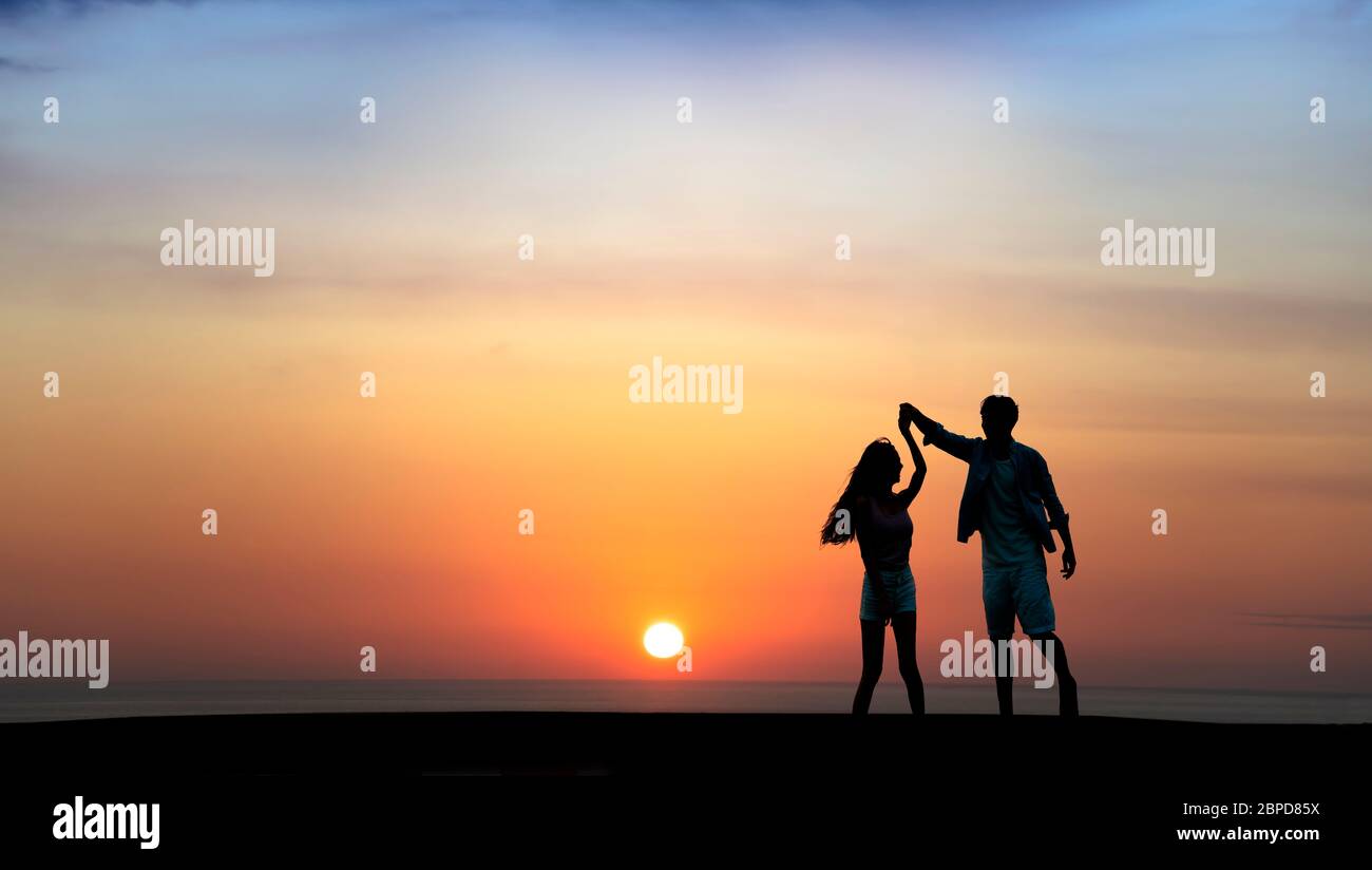 Happy Romantic junge Paar tanzen am Strand bei Sonnenuntergang Stockfoto