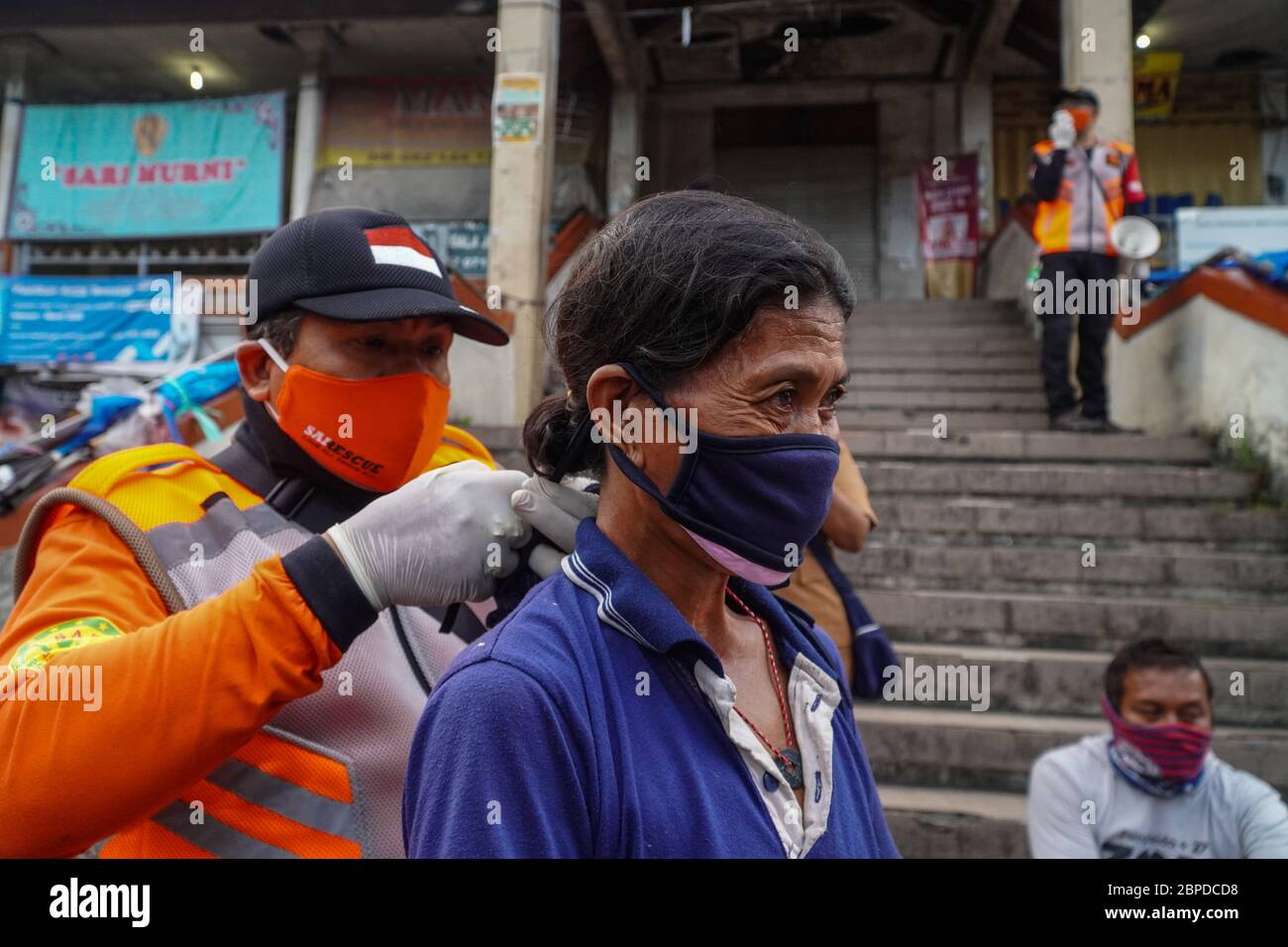 Gianyar, Bali, Indonesien. Mai 2020. Ein Offizier ersetzt die alte Facemask des Händlers durch die neue. Die Task Force bildet die traditionellen Markthändler von Sukawati aus dem Covid-19 Coronavirus Gesundheitsprotokoll in Gianyar, Bali, Indonesien. Kredit: Dicky Bisinglasi/ZUMA Wire/Alamy Live News Stockfoto