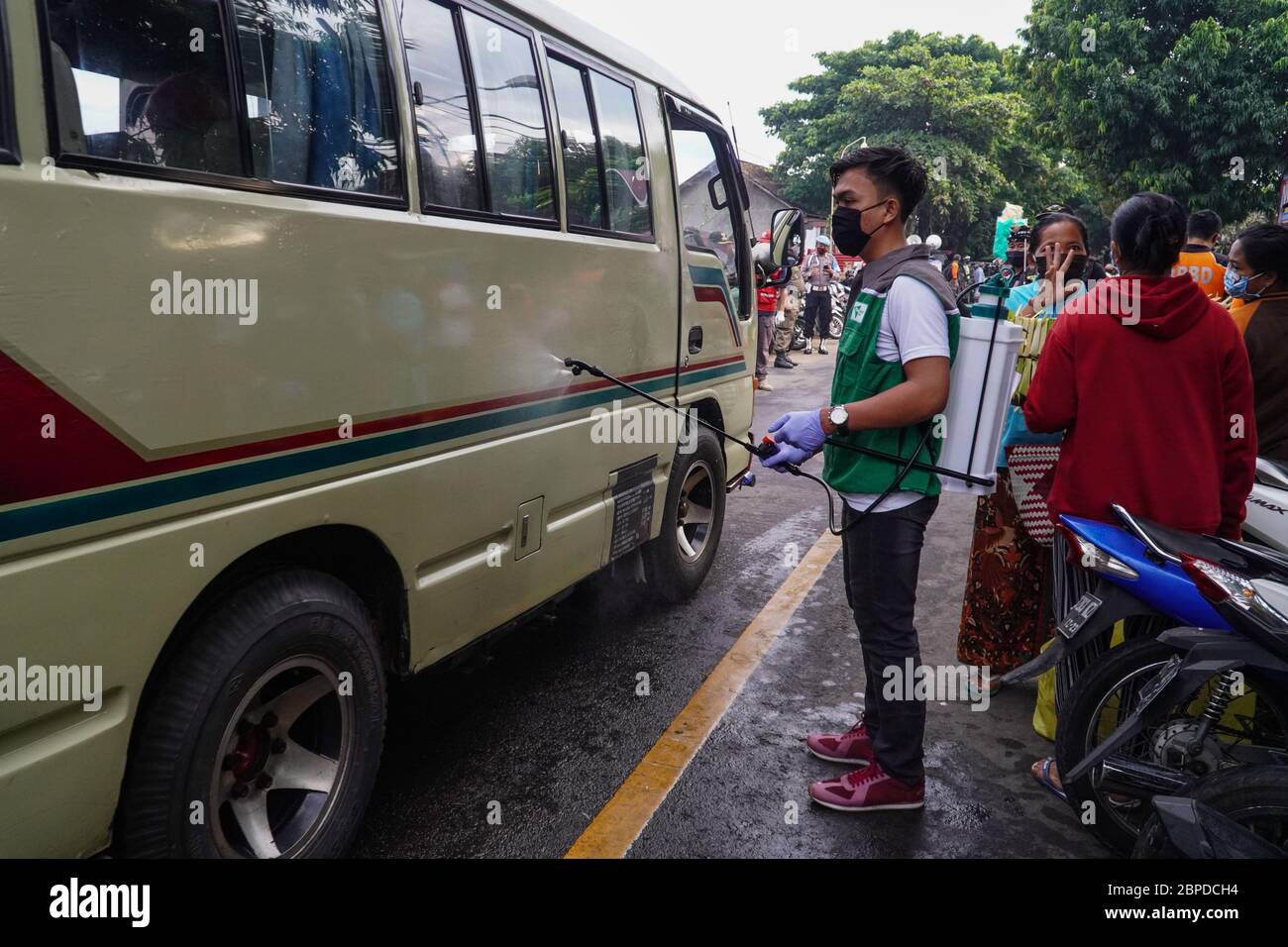 Gianyar, Bali, Indonesien. Mai 2020. Ein freiwilliger Mann sprüht Desinfektionsmittel auf ein vorbeifahrender Wagen. Die Task Force bildet die traditionellen Markthändler von Sukawati aus dem Covid-19 Coronavirus Gesundheitsprotokoll in Gianyar, Bali, Indonesien. Kredit: Dicky Bisinglasi/ZUMA Wire/Alamy Live News Stockfoto