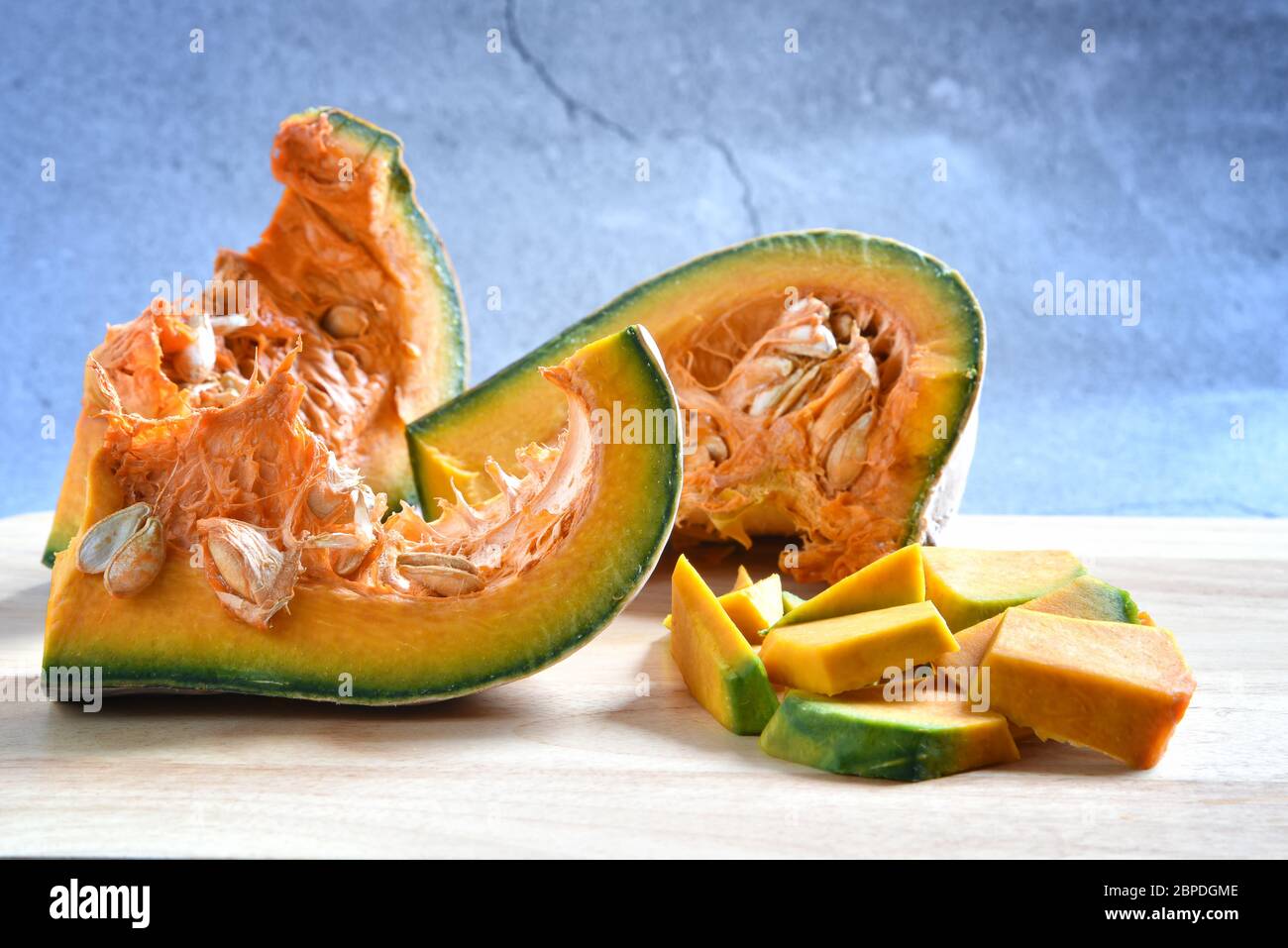 Kürbis Scheiben gewürfelt und Kürbis Brei auf einem Holz in dunklem Hintergrund. Konzept Kochen gehackten Kürbis. Lebensmittel Hintergrund. Selektiver Fokus. Stockfoto