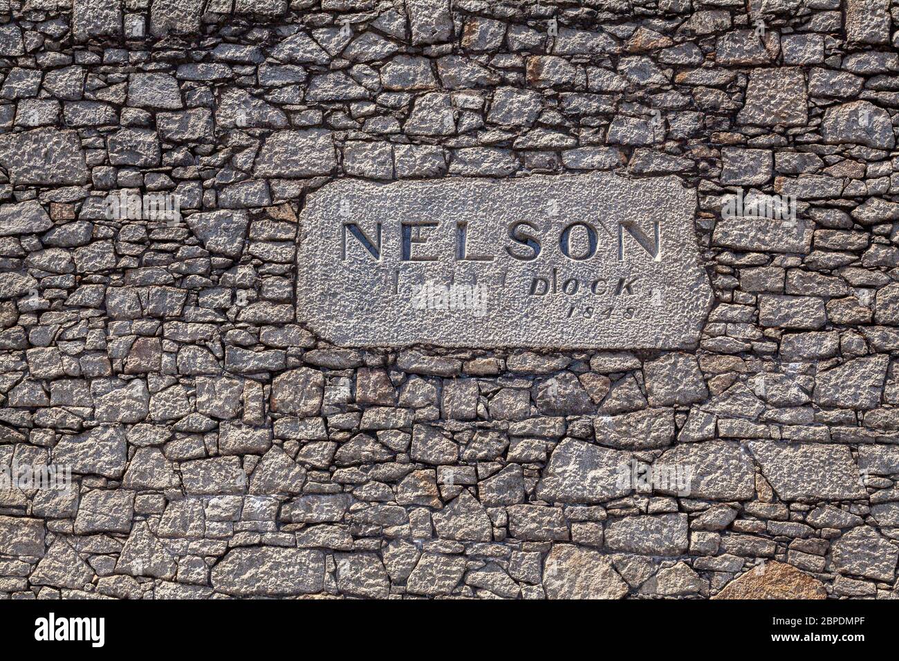 Schild an der alten Steinmauer des Nelson Dock, Teil des Hafens von Liverpool, England Stockfoto