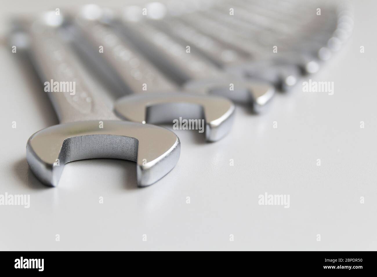 Schraubenschlüssel. Viele Schraubenschlüssel. Grauer Hintergrund. Satz von Schraubenschlüsseln in verschiedenen Größen auf grauem Hintergrund.Nahaufnahme. Unscharfer Hintergrund. Stockfoto