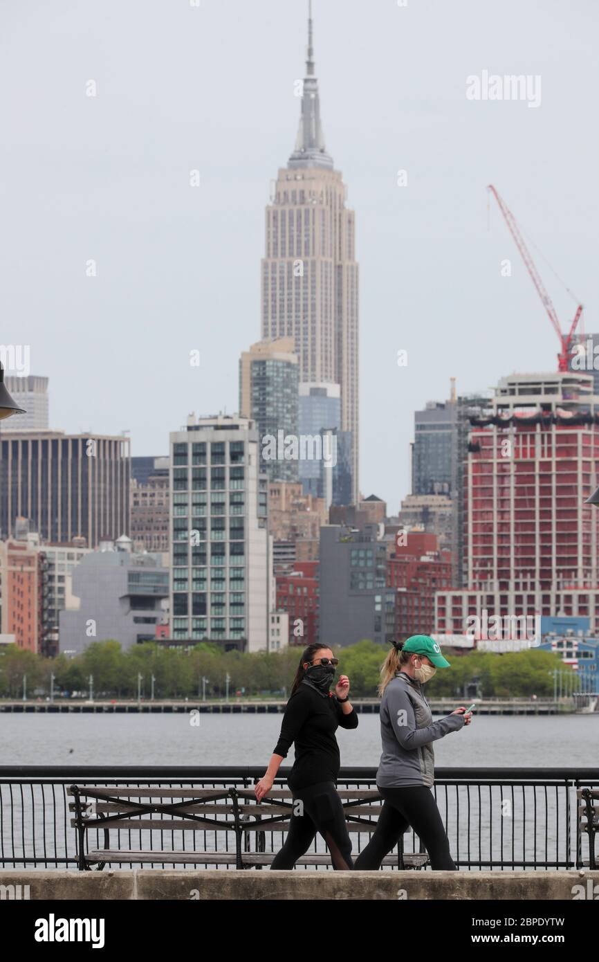 New York, USA. Mai 2020. Menschen, die Gesichtsmasken tragen, genießen den Blick auf die Skyline von Manhattan gegenüber dem Hudson River in Hoboken in New Jersey, USA, 18. Mai 2020. Die Anzahl der COVID-19-Fälle in den Vereinigten Staaten überstieg 1.5 Millionen am Montag, erreichte 1,500,753 von 16:03 Uhr (2003 GMT), nach dem Center for Systems Science and Engineering (CSSE) an der Johns Hopkins University. Die nationale Todesrate von COVID-19 stieg laut CSSE auf 90,312. Kredit: Wang Ying/Xinhua/Alamy Live News Stockfoto