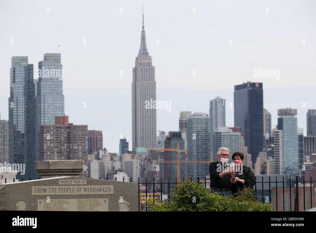 New York, USA. Mai 2020. Menschen, die Gesichtsmasken tragen, fotografieren die Skyline von Manhattan aus Weehawken in New Jersey, USA, am 18. Mai 2020. Die Anzahl der COVID-19-Fälle in den Vereinigten Staaten überstieg 1.5 Millionen am Montag, erreichte 1,500,753 von 16:03 Uhr (2003 GMT), nach dem Center for Systems Science and Engineering (CSSE) an der Johns Hopkins University. Die nationale Todesrate von COVID-19 stieg laut CSSE auf 90,312. Kredit: Wang Ying/Xinhua/Alamy Live News Stockfoto