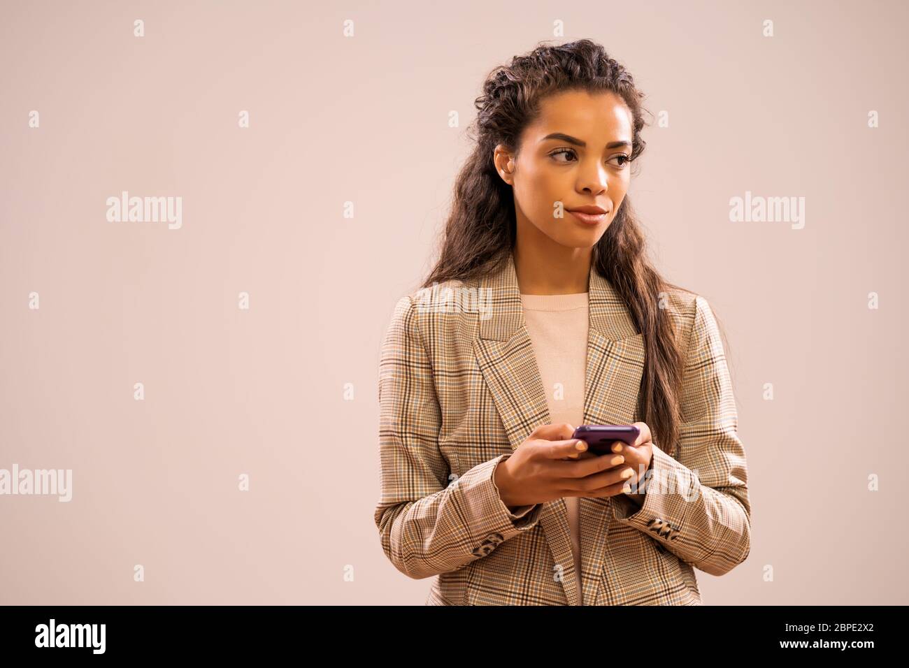 Studio-Aufnahme Porträt der schönen afroamerikanischen Ethnizität Geschäftsfrau mit Smartphone. Stockfoto