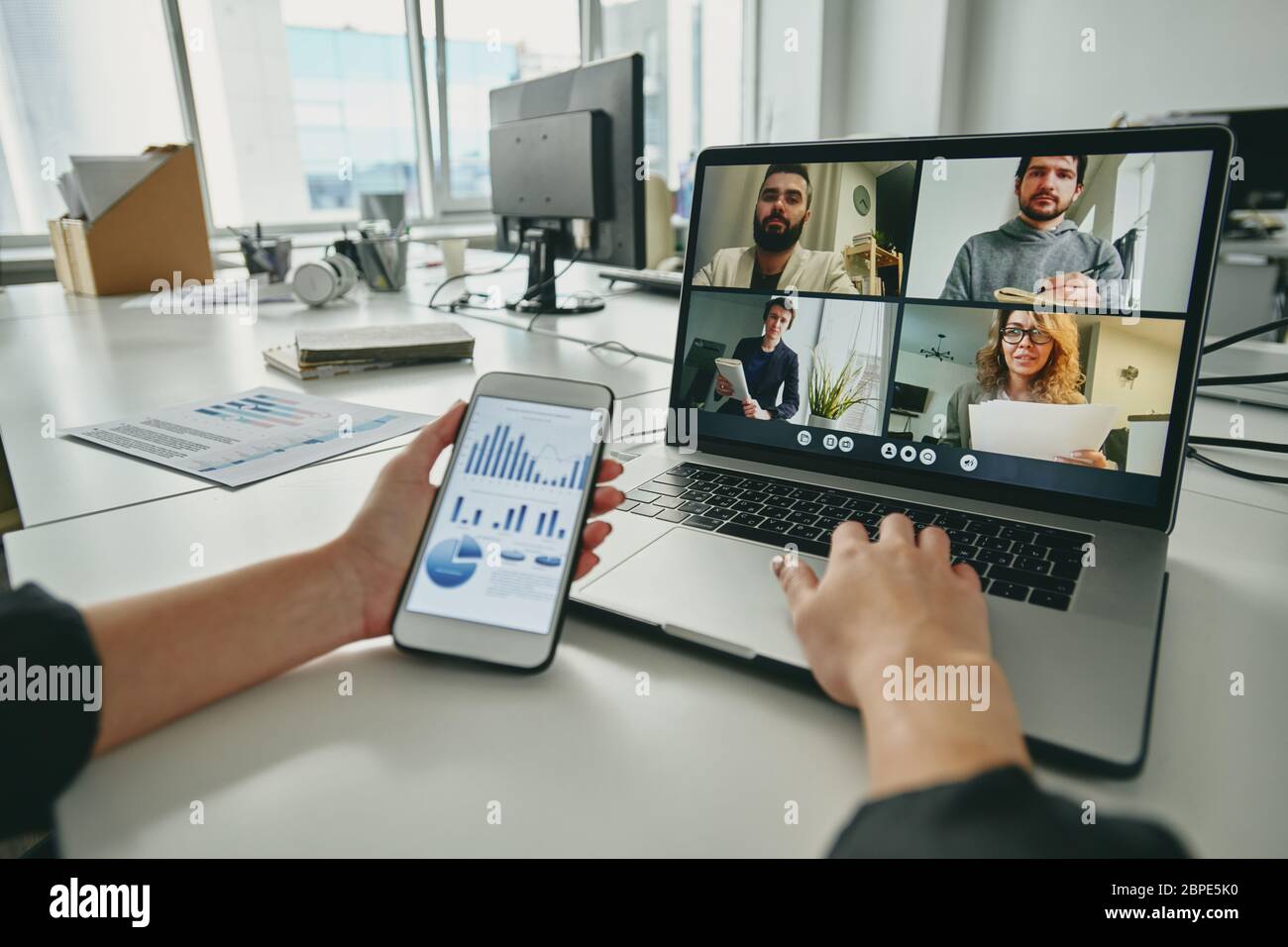 Meeting per Videokonferenz-App: manager mit Verkaufsanalyse-Graph während der Besprechung der Strategie mit Kollegen per Video-Chat auf dem Laptop Stockfoto