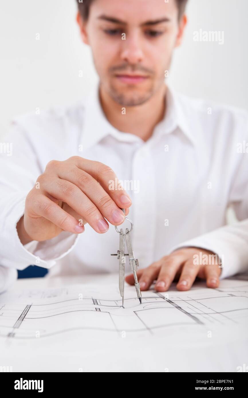 Closeup abgeschnitten Bild eines jungen männlichen Architekten arbeiten auf Blaupausen auf einem Tisch ausgebreitet Stockfoto
