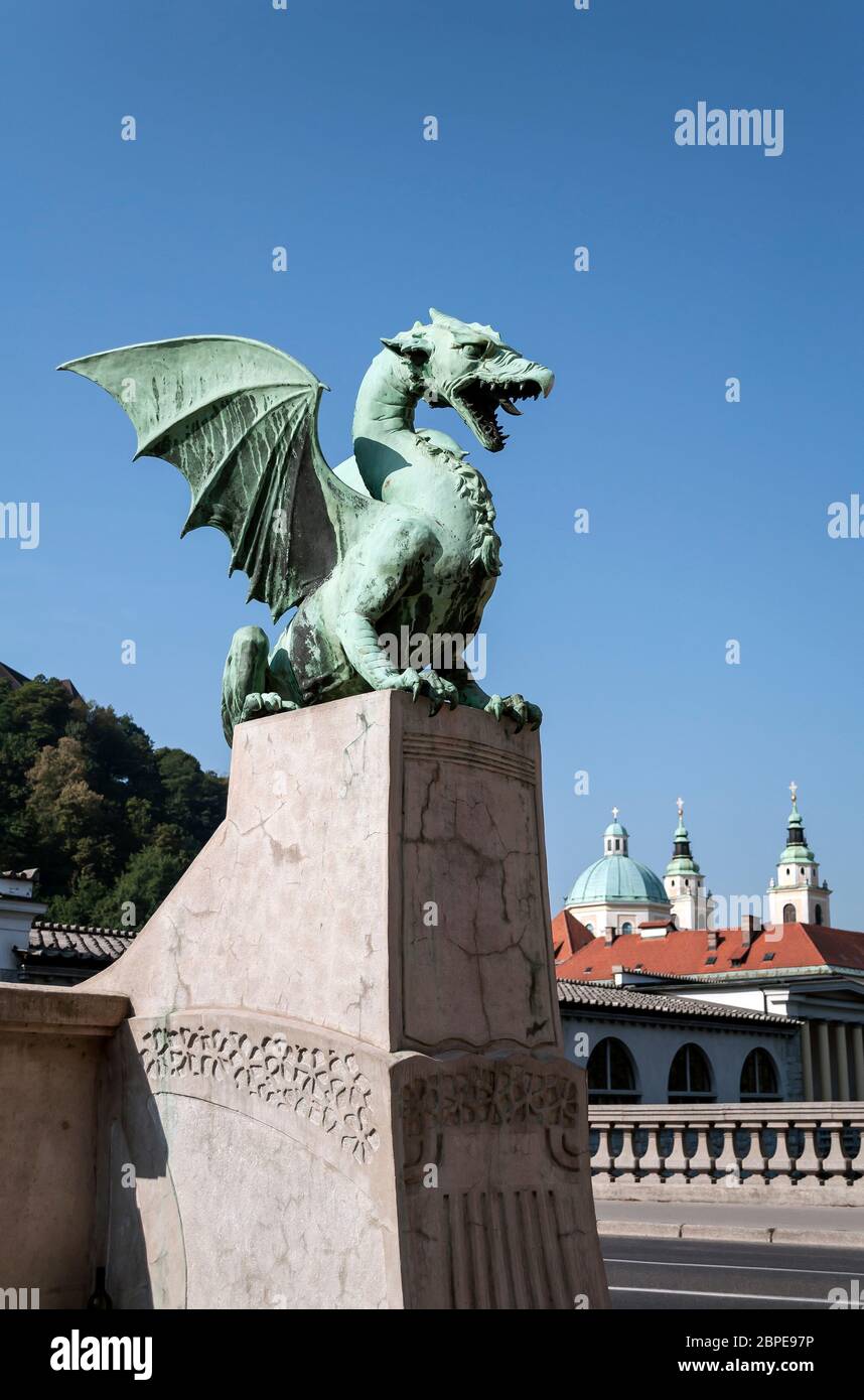 Dragon Bridge mit St. Nikolaus-Kathedrale im Hintergrund, in Ljubljana, Slowenien. Stockfoto
