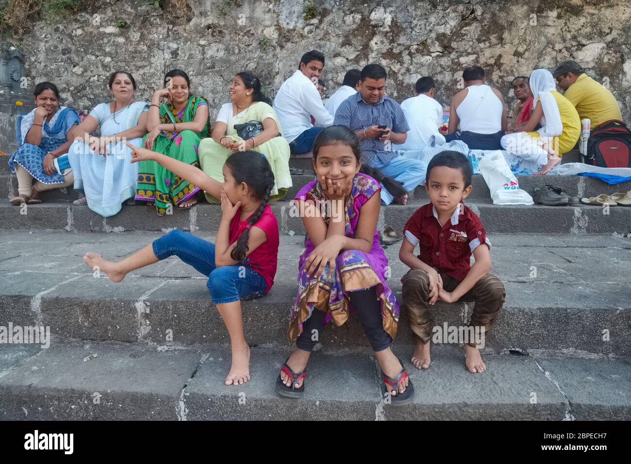 Spielerische Kinder und ältere Mitglieder einer erweiterten indischen Familie, Männer und Frauen, besuchen heilige (Hindu) Website Banganga Tank in Walkeshwar, Mumbai, Indien Stockfoto