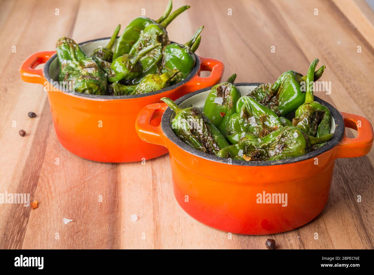 Padron gegrillte Paprika mit Salz und Pfeffer in kleinen Gusseisen Töpfe Stockfoto