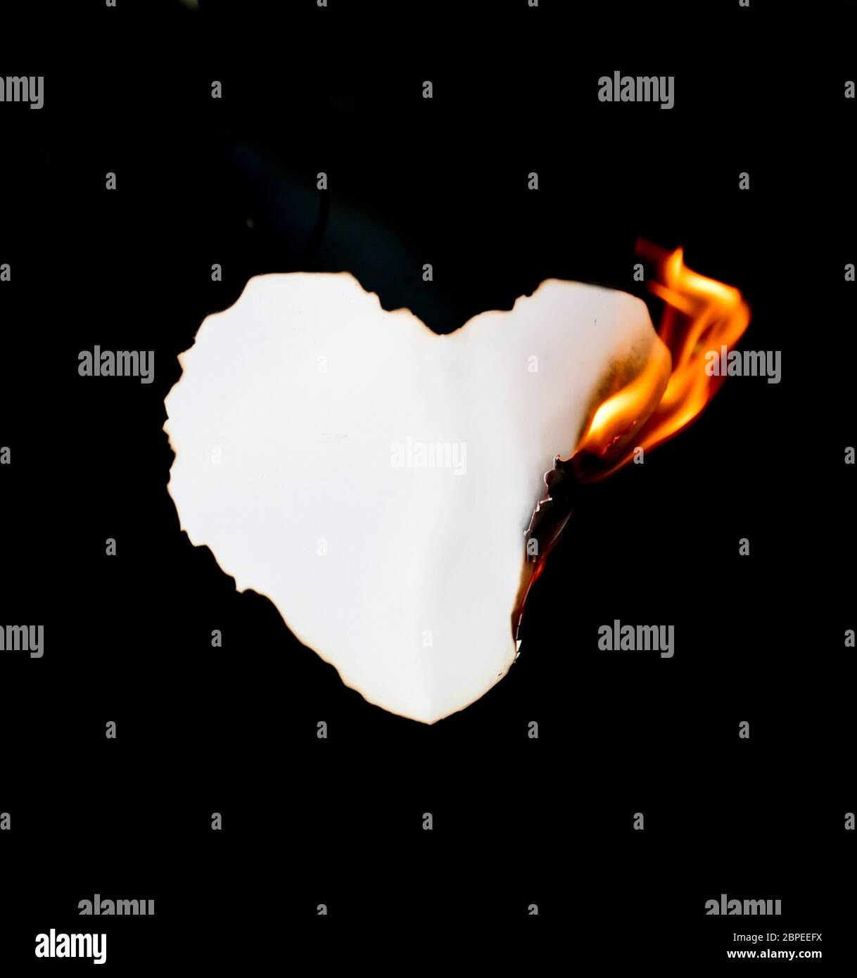 Herz Form Papier Brennen auf schwarzem Hintergrund Stockfoto