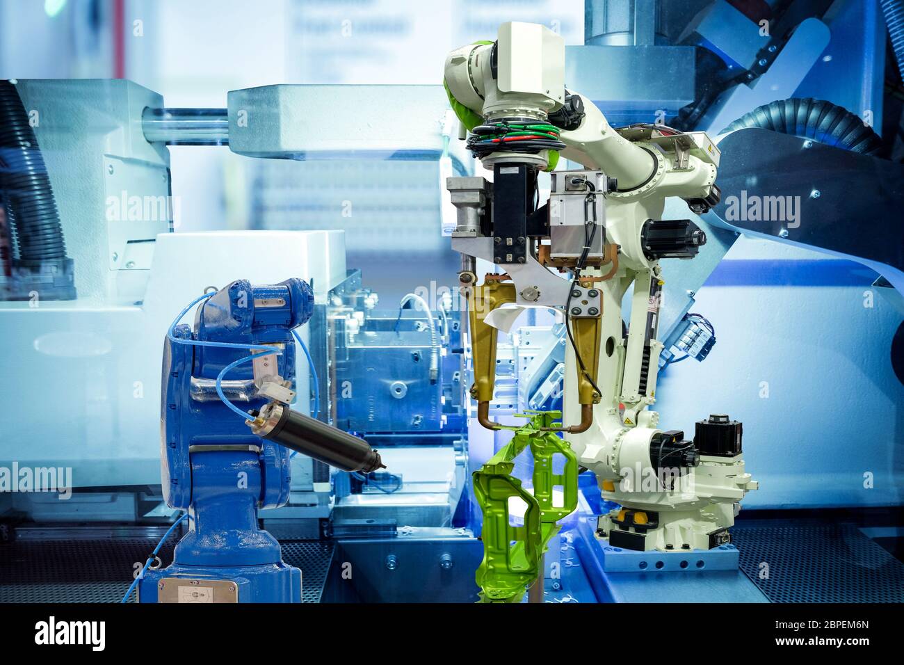 Industrielle Robotik, die mit Autoteil des Fahrzeugs auf intelligente Fabrik, auf Maschine Blauton Farbhintergrund, Industrie 4.0 und Technologie. Stockfoto