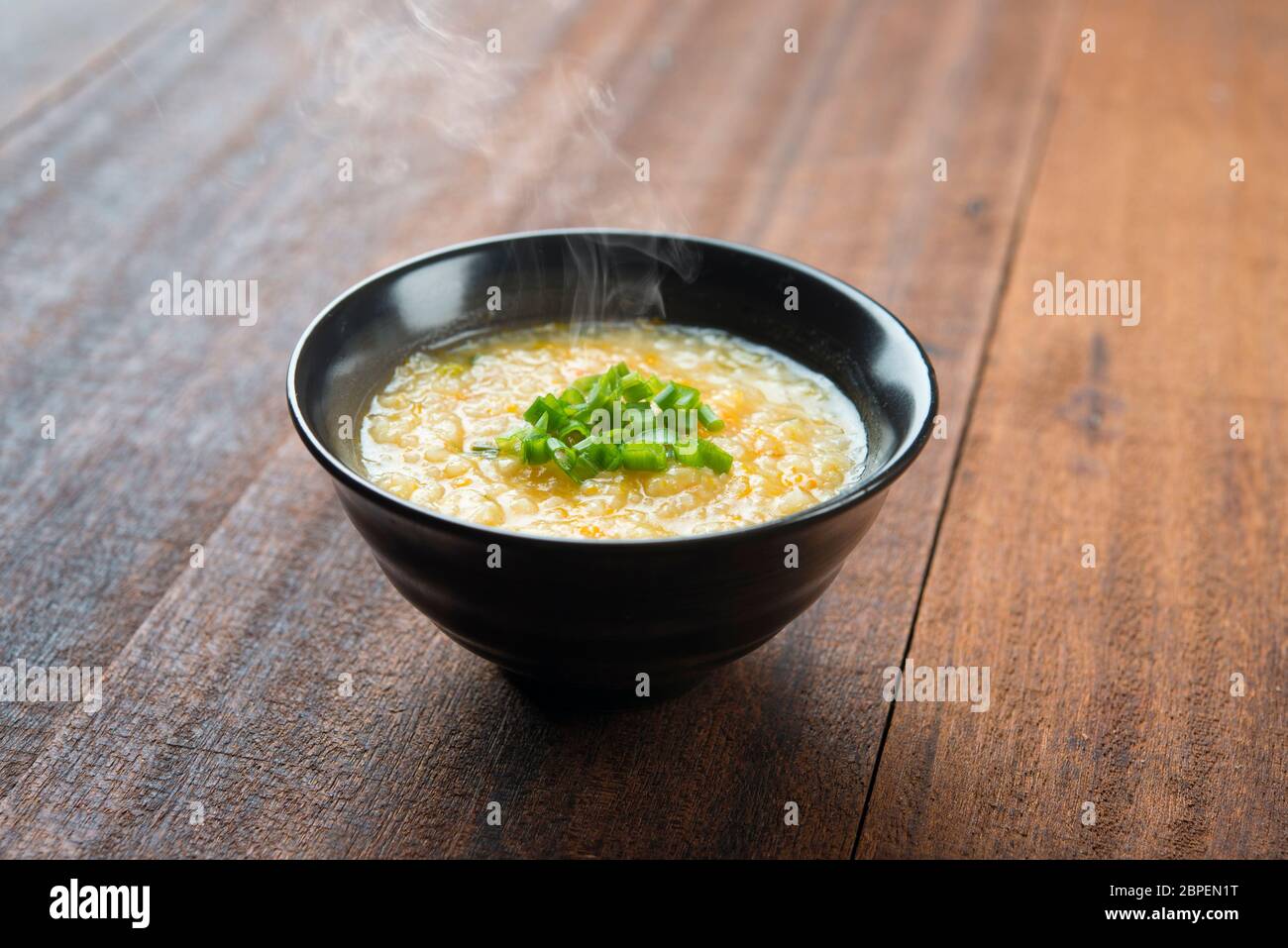 Im asiatischen Stil congee Schüssel auf hölzernen Tisch Hintergrund. Stockfoto