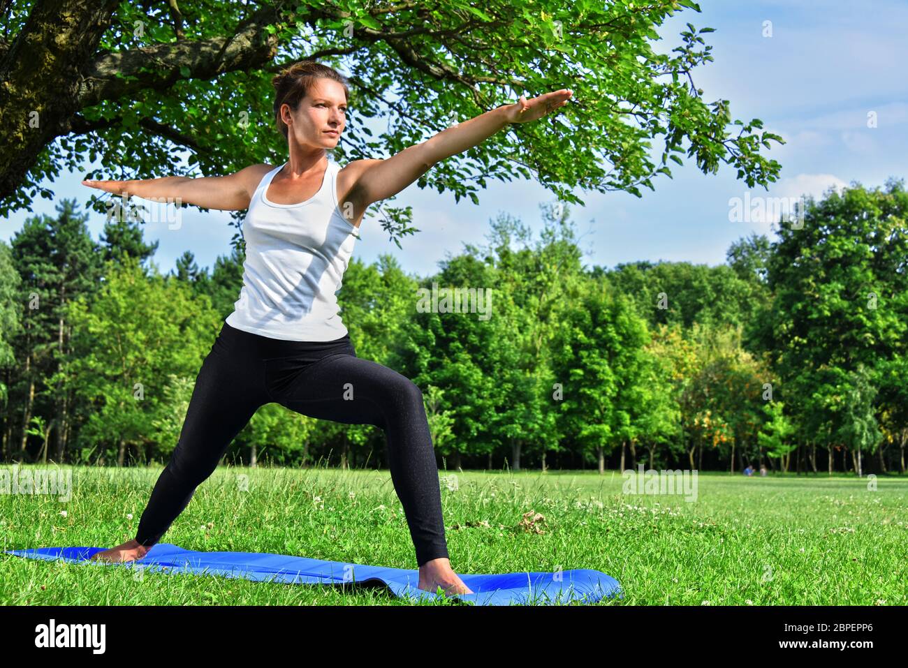 Junge Frau während der Yoga-Meditation im Park. Stockfoto