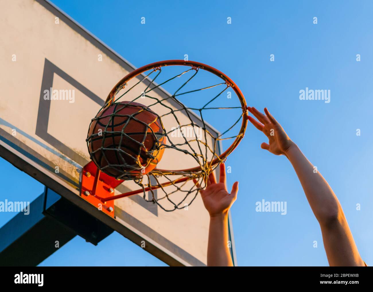 Street Basketball Slam Dunk Wettbewerb. Nahaufnahme des Balls, der in den Reifen fällt. Urban Jugend Spiel. Konzept des Erfolgs, Punkte sammeln und gewinnen Stockfoto