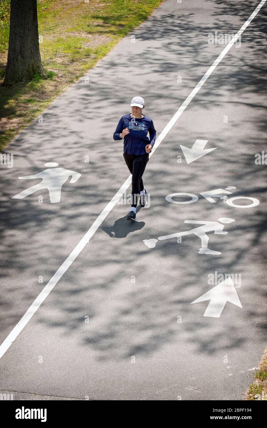 Eine Läuferin joggt auf einem Pfad nahe der Bayside Marina in Queens, New York City Stockfoto