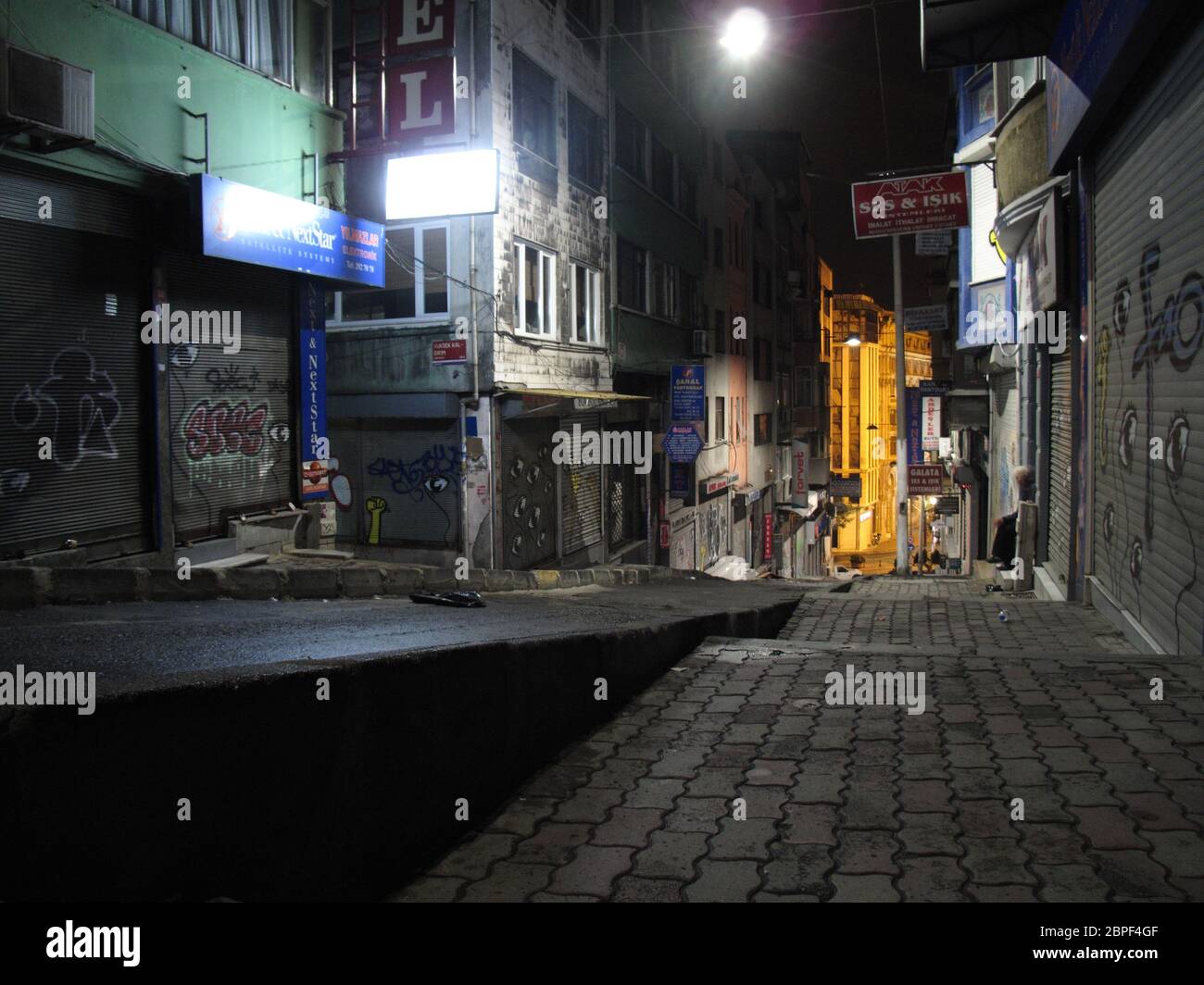 Nachtansicht der Fußgängerzone mit Graffiti-bedeckten Wänden und Metallgitten in der Gegend von Galata in Istanbul, Türkei Stockfoto