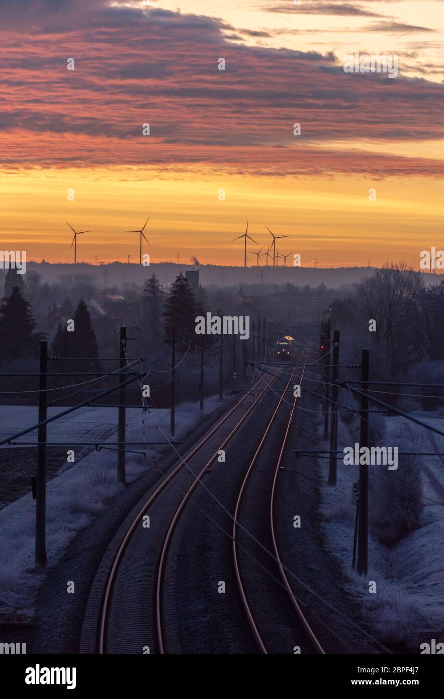 Eisenbahn überquert gefroren Natur bei Sonnenaufgang unter einem goldenen Himmel. Winter Landschaft in der Nähe der deutschen Stadt Schwäbisch Hall Stockfoto