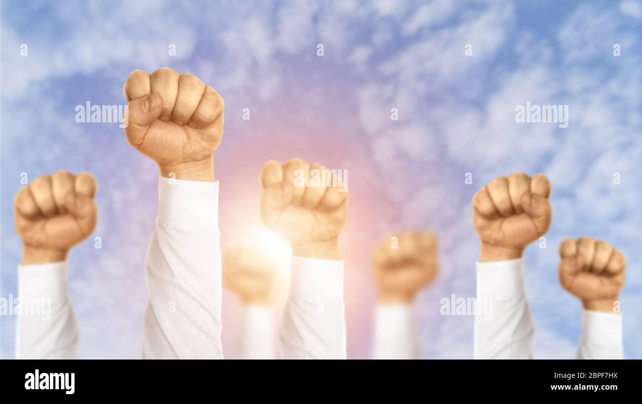 Entschlossenheit zum Erfolg. Kreative Collage mit Geschäftsleuten, die ihre Fäuste gegen den blauen Himmel erheben Stockfoto