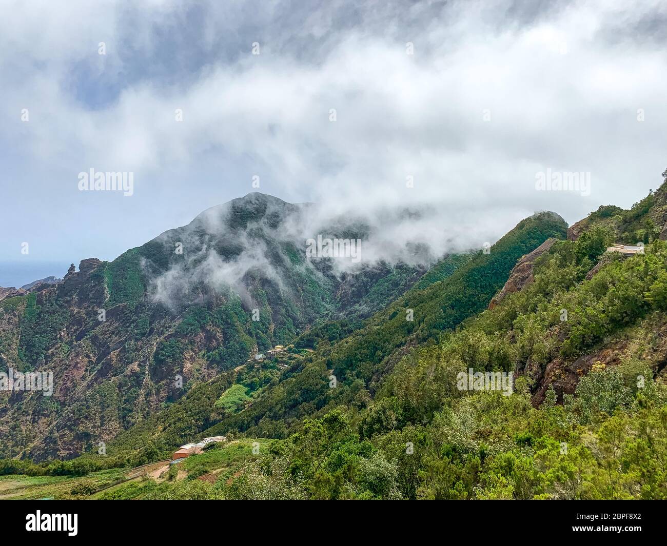 Panoramabild der Berge im Anaga Rural Park an einem sonnigen Tag mit weißen Wolken und dem Meer im Hintergrund, Teneriffa - Kanarische Inseln Stockfoto