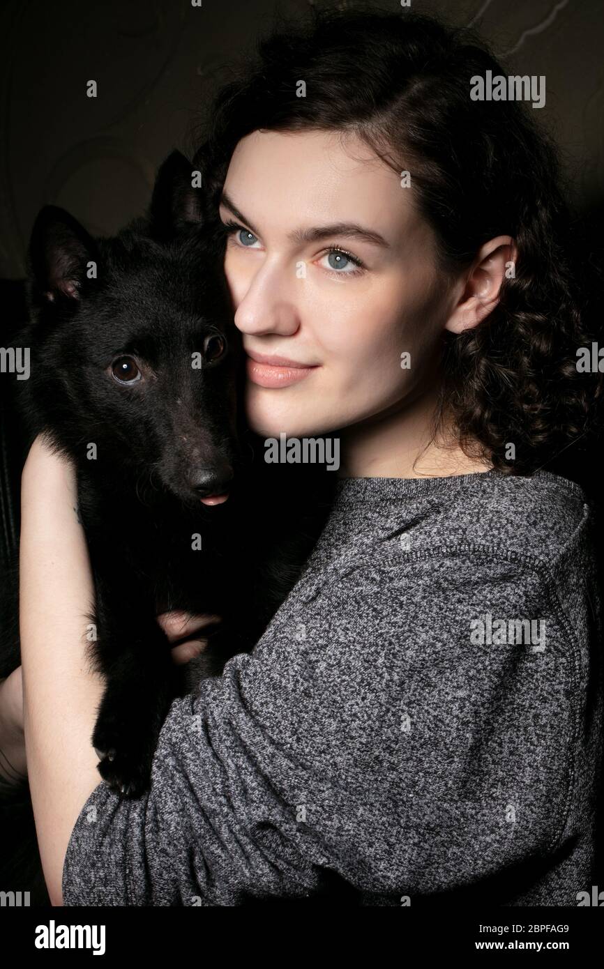 Porträt eines schönen Mädchens mit einem schwarzen Hund.Frau mit einem Spediteur. Stockfoto