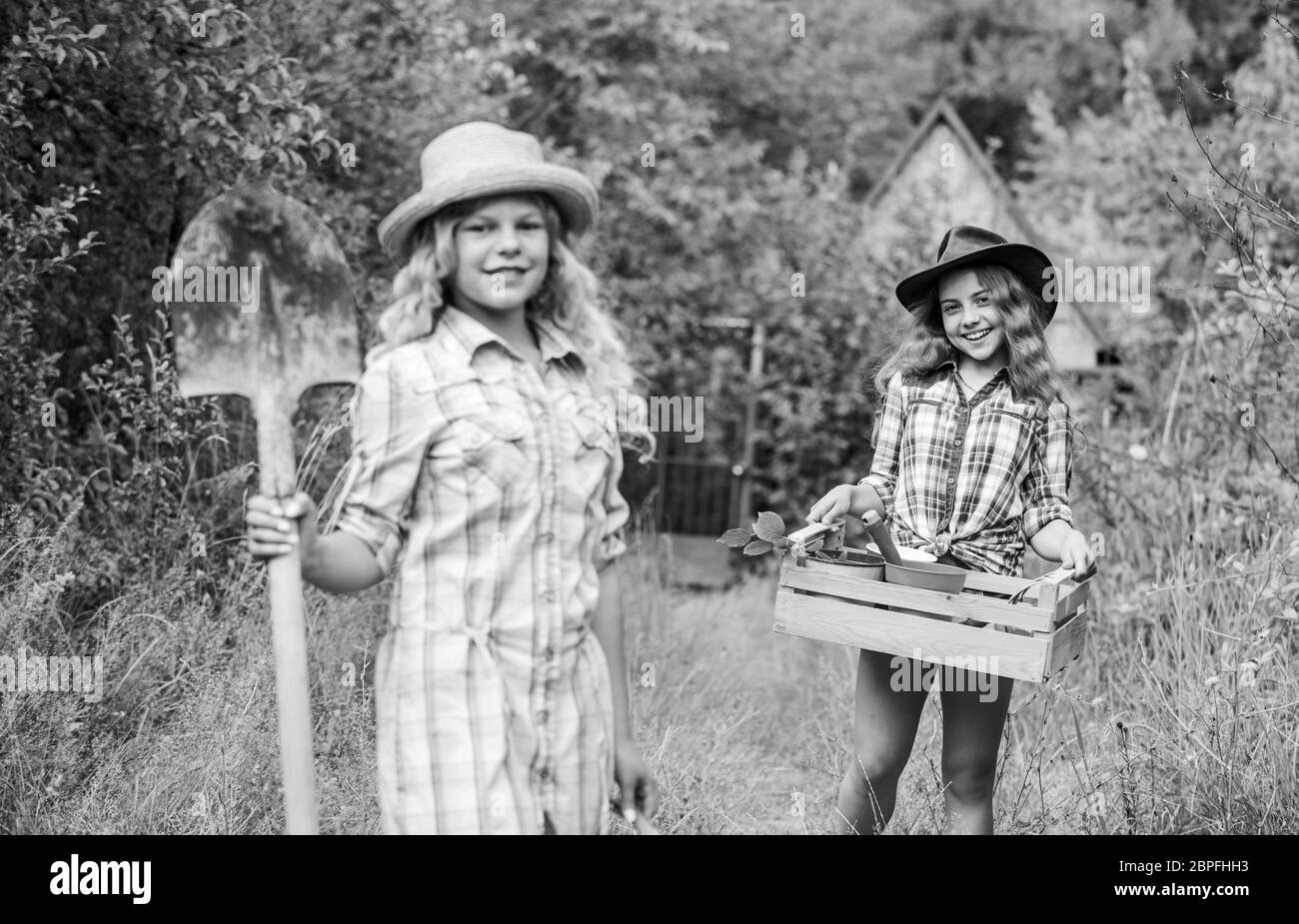 Ein grünes Leben leben, Ökologie und Umweltschutz, Erdtag, Sommerfamilienbetrieb, Landwirtschaft, Frühlingslandseite, kleine Mädchen Bauern im Dorf, Kinder halten Gartengeräte. Stockfoto