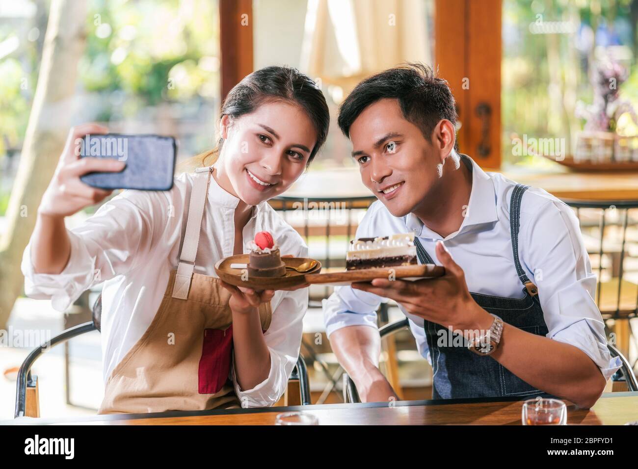 Paar asiatische zwei Partner von Kleinunternehmen Besitzer unter Selfie und präsentiert die Bäckerei im Café, wenn Reccord vlog, Kuchen und Dessert, entrepren Stockfoto