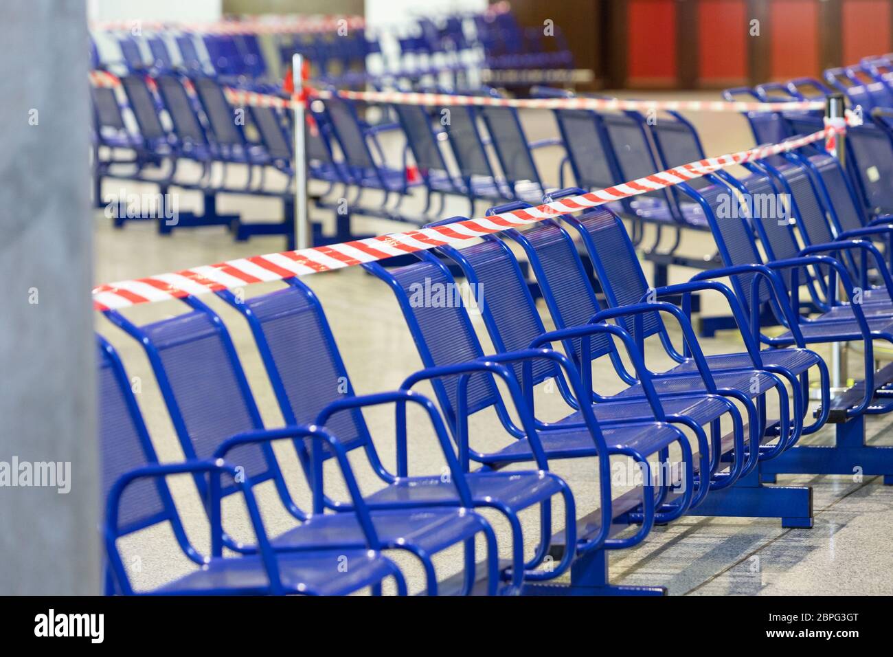 Dehntes Schutzband auf den Stühlen. Es ist verboten, während der Coronavirus-Pandemie auf öffentlichen Plätzen zu sitzen, um die Menschen vor Infektionen zu schützen. Stockfoto