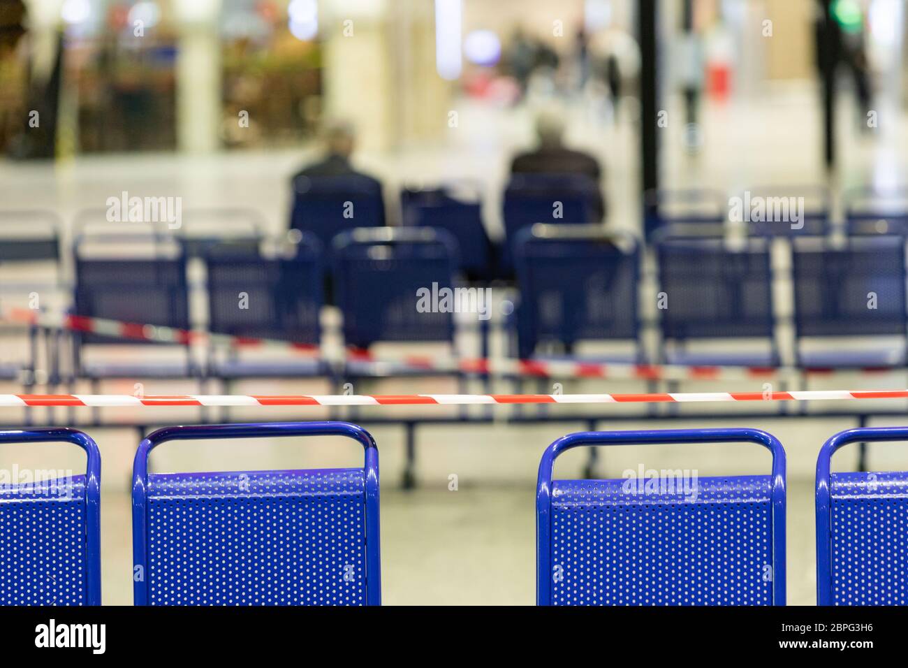 Dehntes Schutzband auf den Stühlen. Es ist verboten, während der Coronavirus-Pandemie auf öffentlichen Plätzen zu sitzen, um die Menschen vor Infektionen zu schützen Stockfoto