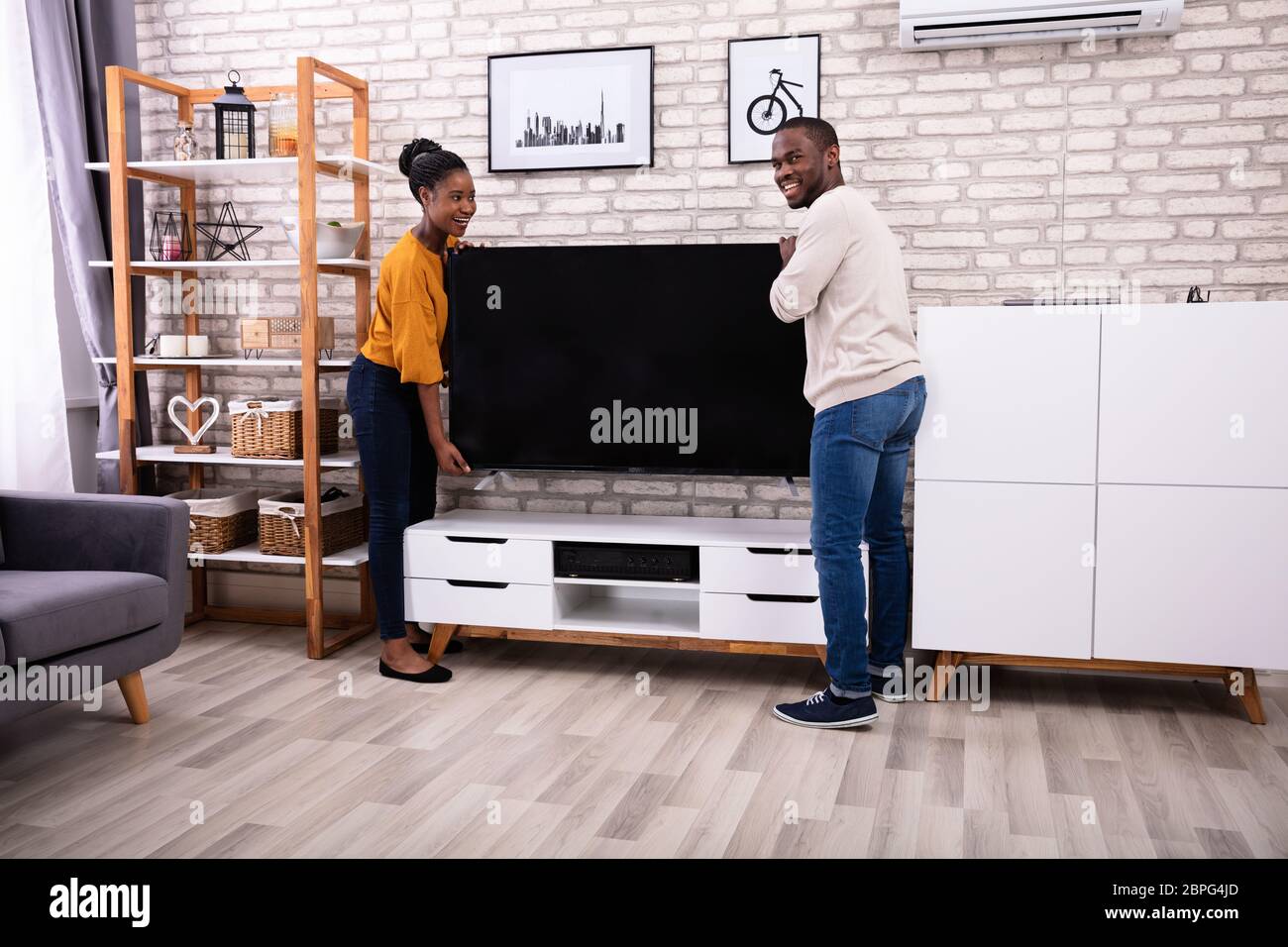 Seitenansicht des jungen afrikanischen Paar heben Fernsehen zu Hause Stockfoto
