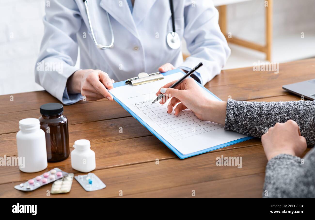 Arzt schlägt vor, Fragebogen für Patienten auszufüllen, abgeschnitten Stockfoto