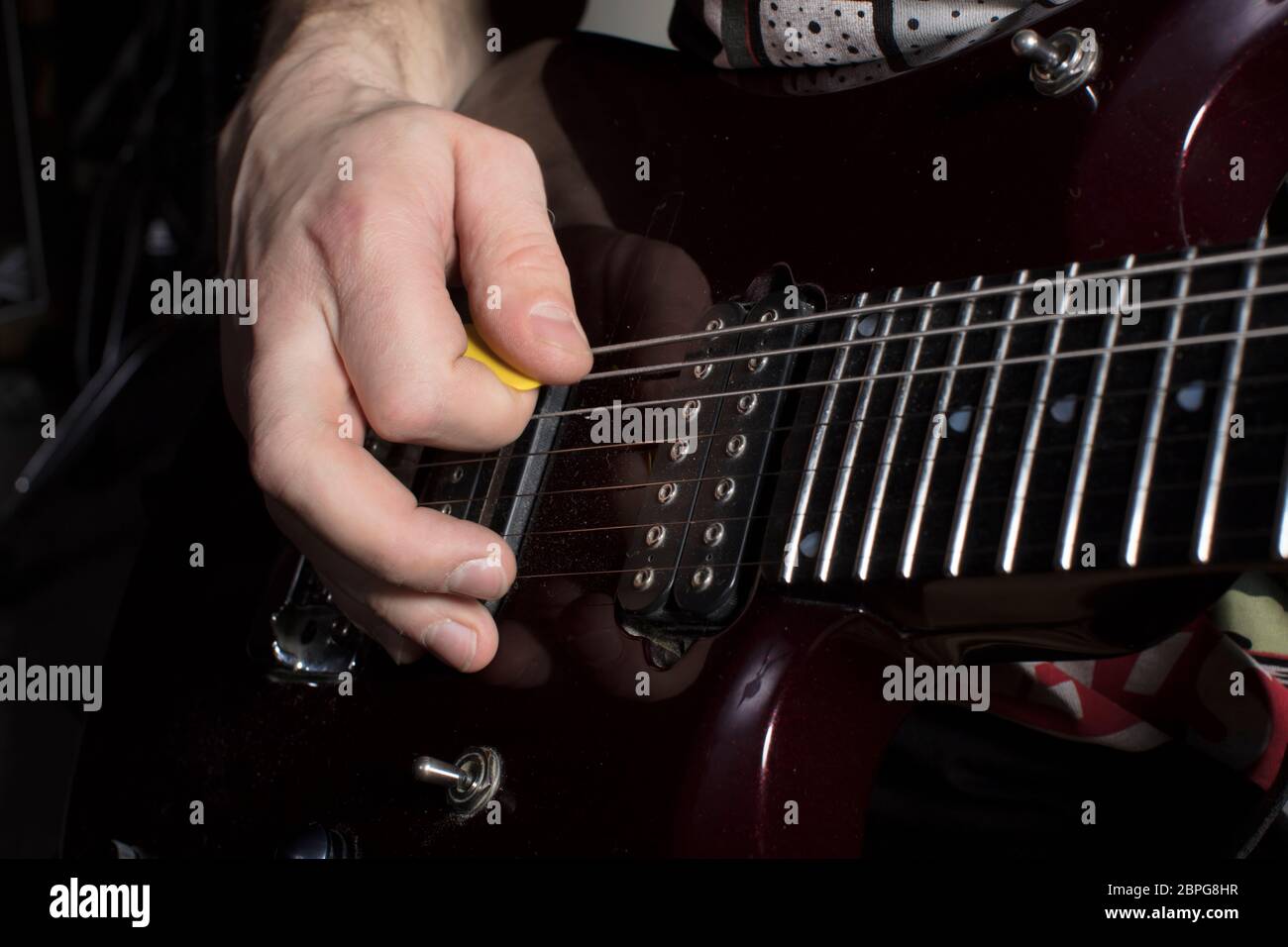 Hand spielt Gitarre. Iterieren Sie über die Strings. Stockfoto