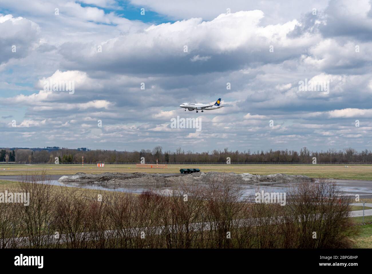 München, Deutschland - 03 29 2018: Flugzeug der Lufthansa Airline landet mit bewölktem Himmel auf dem Flughafen München Stockfoto