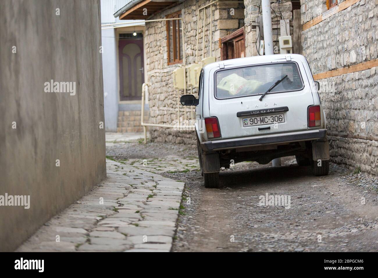 Ein russischer Lada Niva 4x4 parkte in den engen gepflasterten Gassen von Lahic in Aserbaidschan Stockfoto