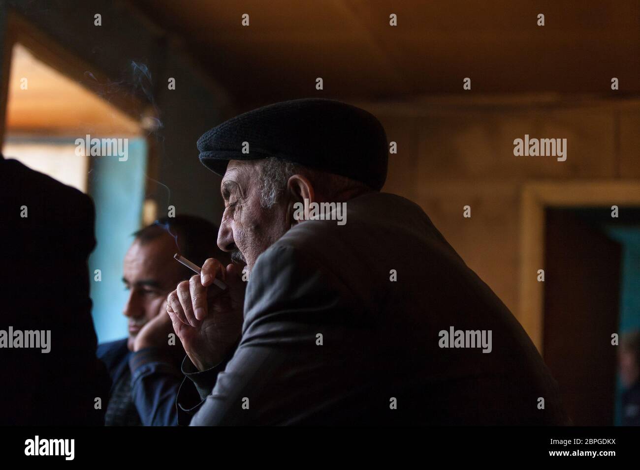 Männer im Dorf Lahic treffen sich im Teeladen und spielen Dominos, während sie Tee trinken und Zigaretten rauchen in Lahic Aserbaidschan. Stockfoto