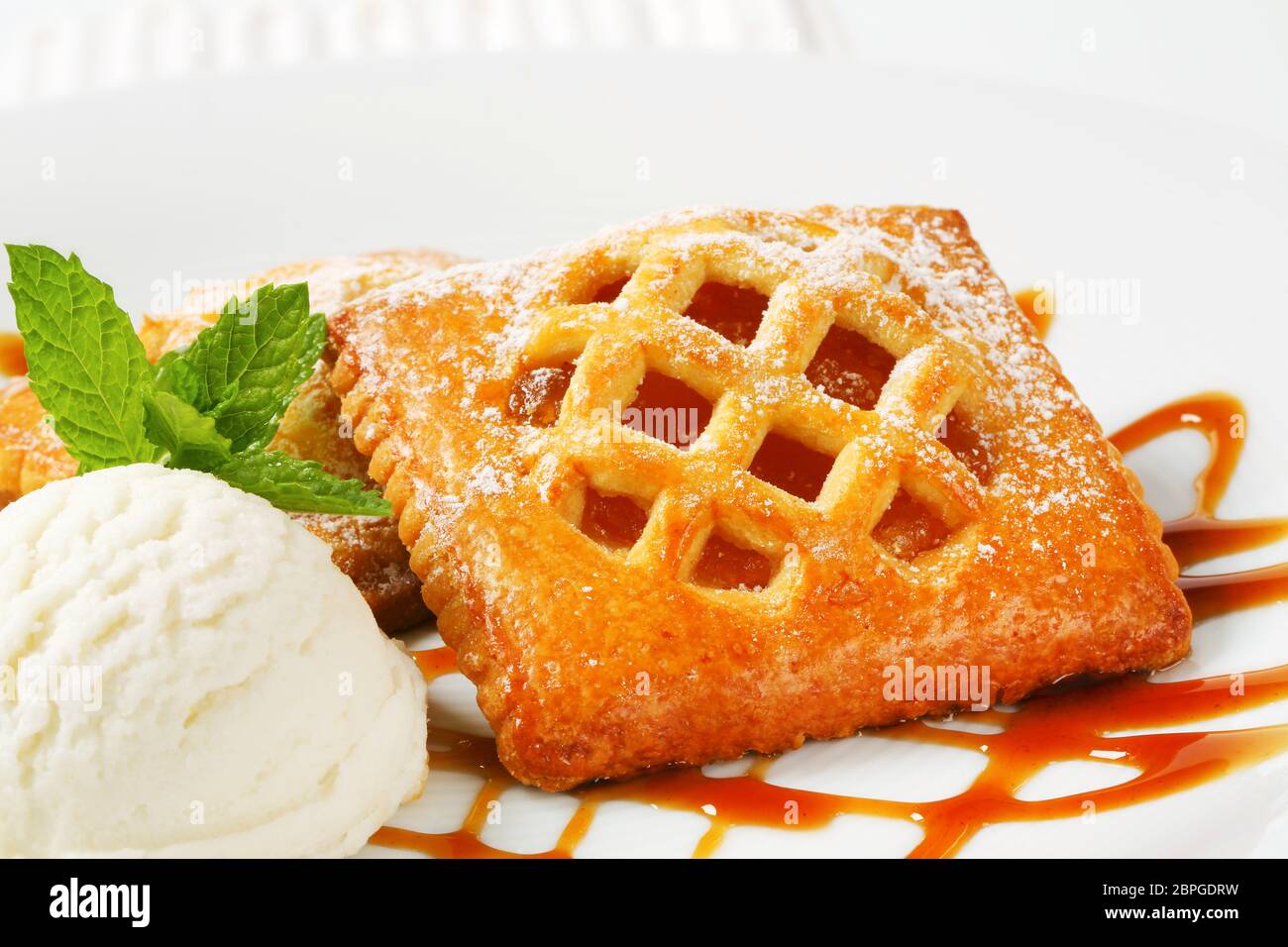 Wenig Gitter - erstklassige Aprikosen Kuchen mit einer Kugel Eis Stockfoto