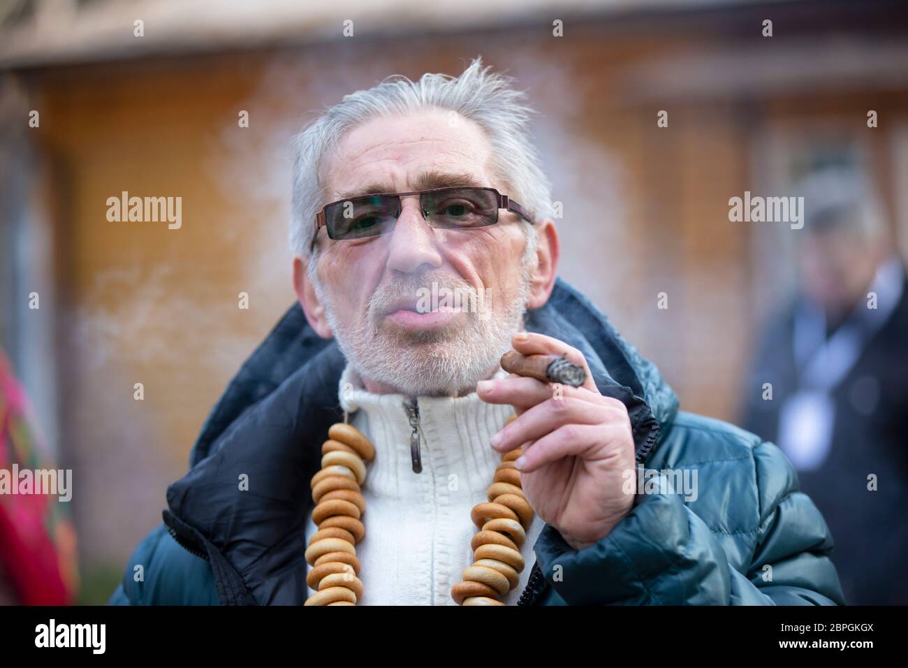 Weißrussland, die Stadt Gomel, 09. März 2019.Weißrussland, die Stadt Gomel, 09. März 2019.Maslenitsa.EIN Mann mit einer Zigarre auf dem Festival Maslenitsa. Stockfoto