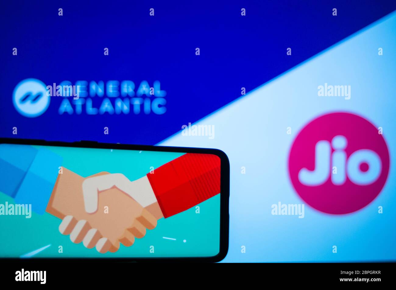 Handy mit Handshake-Bildschirm und General atlantic und jio im Hintergrund Stockfoto