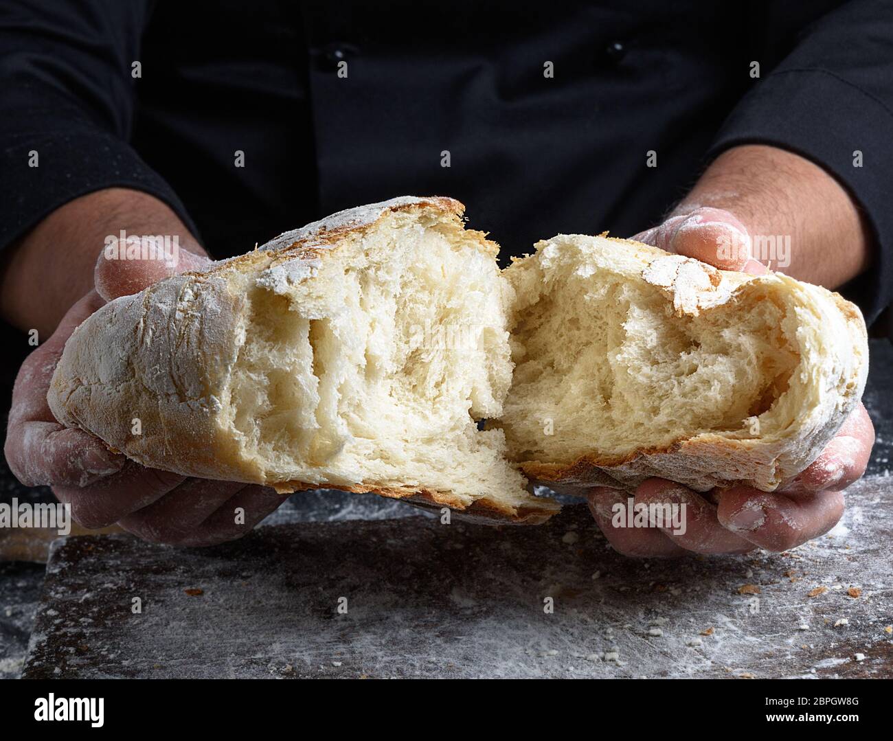 Köche Händen halten Hälften von frisch gebackenen weißen Mehl von Weizen Brot Stockfoto