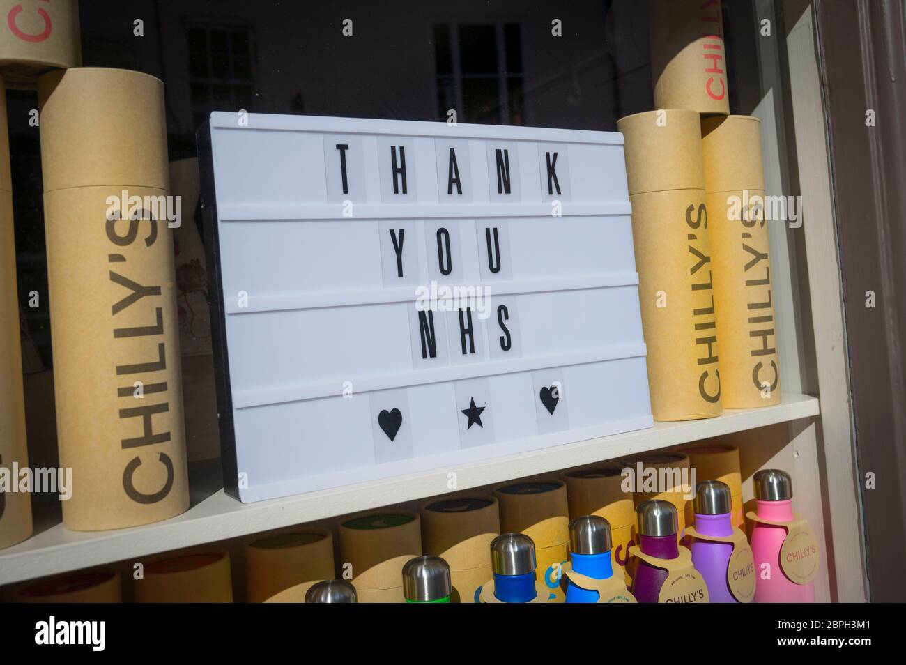 Unterstützung für die NHS , eine Ausstellung von Wasserflaschen in Regenbogenfarben, in einem Schaufenster während der Covid-19 Pandemie, Market Harborough, Leicstershire Stockfoto