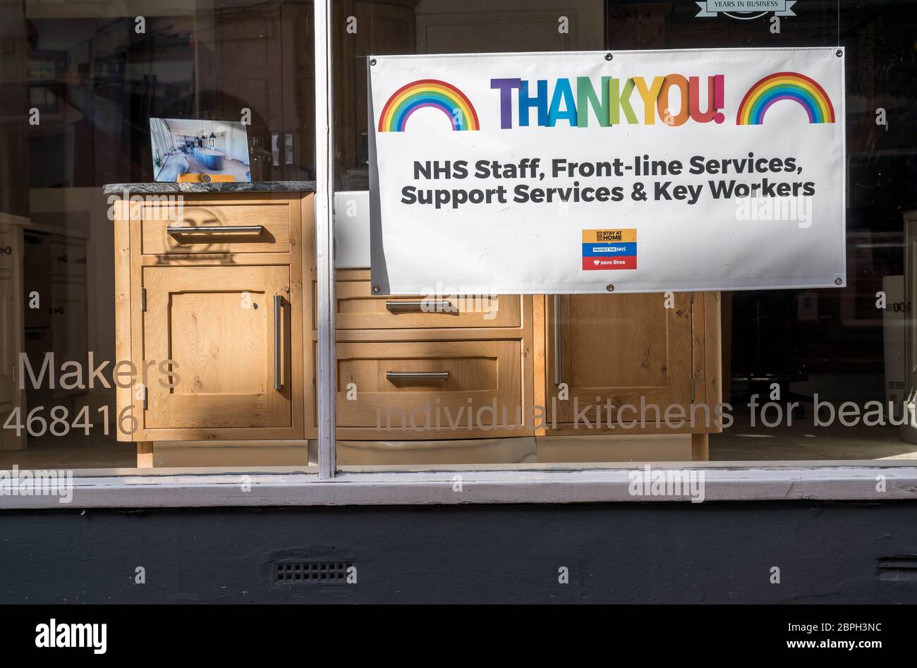 Unterstützung für das NHS Regenbogenschild in einem Schaufenster während der Covid-19 Pandemie, Market Harborough, Leicstershire, England. Stockfoto