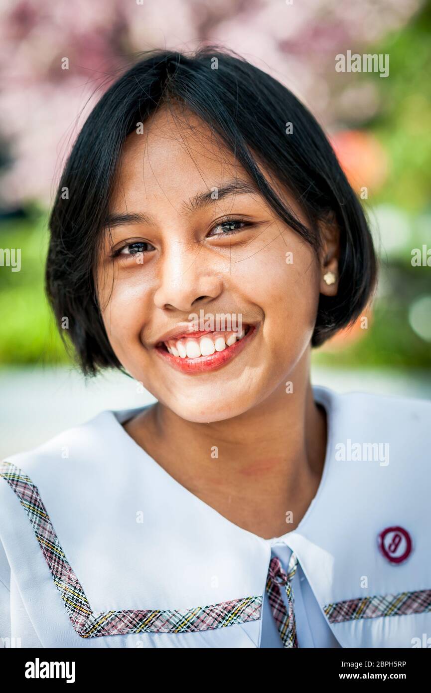 Ein schönes philippinisches Schulmädchen posiert in einem Park in Angeles City, Philippinen. Stockfoto