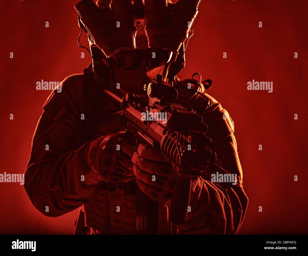 Special Operations Forces Soldat, Terrorismusbekämpfung assault Team Kämpfer mit Nachtsichtgerät auf Helm und red dot Laser Anblick auf service Gewehr, Stockfoto