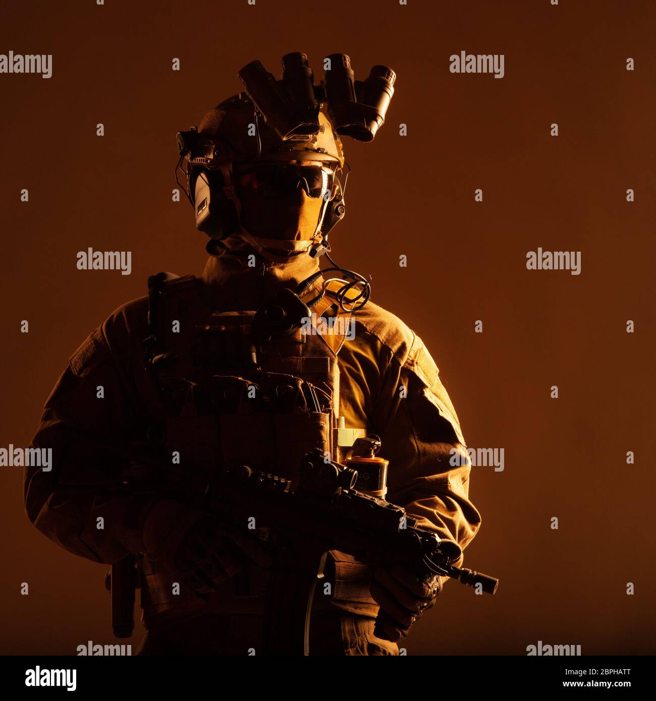 Armee Elite Forces Mitglied, modernen Infanteristen mit versteckten Gesicht, in dem taktischen Munition, ausgestattet radio Headset, nachtsichtgerät am Helm montiert, Stockfoto